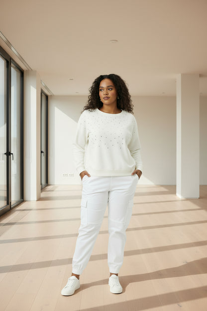 A white long-sleeve crewneck top with small crystals.