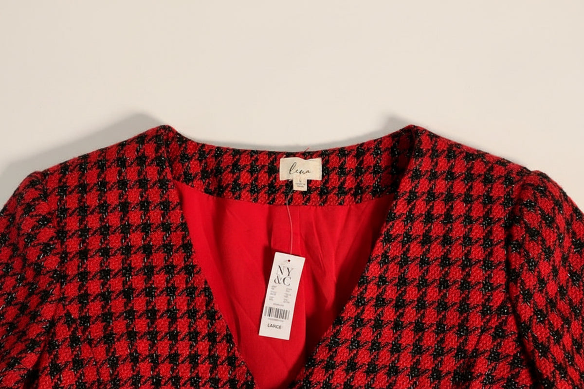 A close-up of a red and black tweed houndstooth. Garment new with NY & Co tag showing a bright red inner lining and a white 'luna' brand neck label.