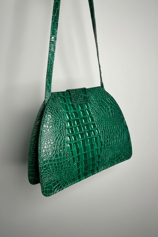 A green faux crocodile-embossed handbag with a structured dome shape and shoulder strap.